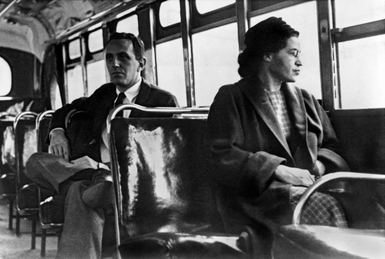 Rosa Parks on a Montgomery bus on December 21, 1956, the day Montgomery's public transportation system was legally integrated. Behind Parks is Nicholas C. Chriss, a UPI reporter covering the event.