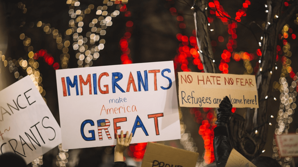 Protesters holding signs in support of immigrants at a rally