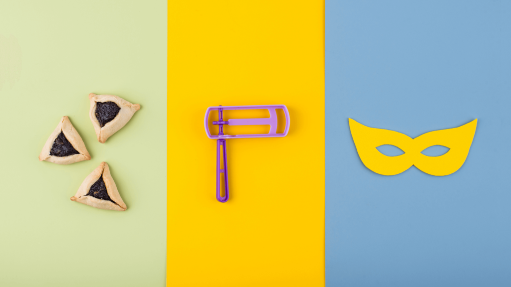 Hamentaschen cookies, a grogger noise maker, and a yellow mask on a tricolored background of yellow, blue, and green.