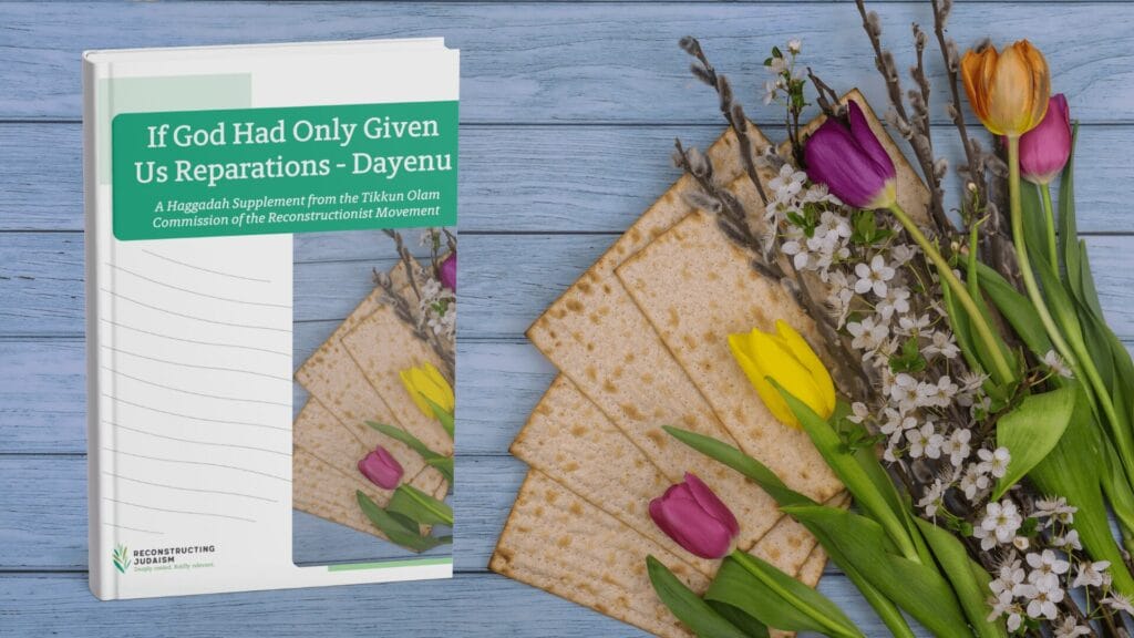 Haggadah, matzah, and spring flowers on a blue wooden table.