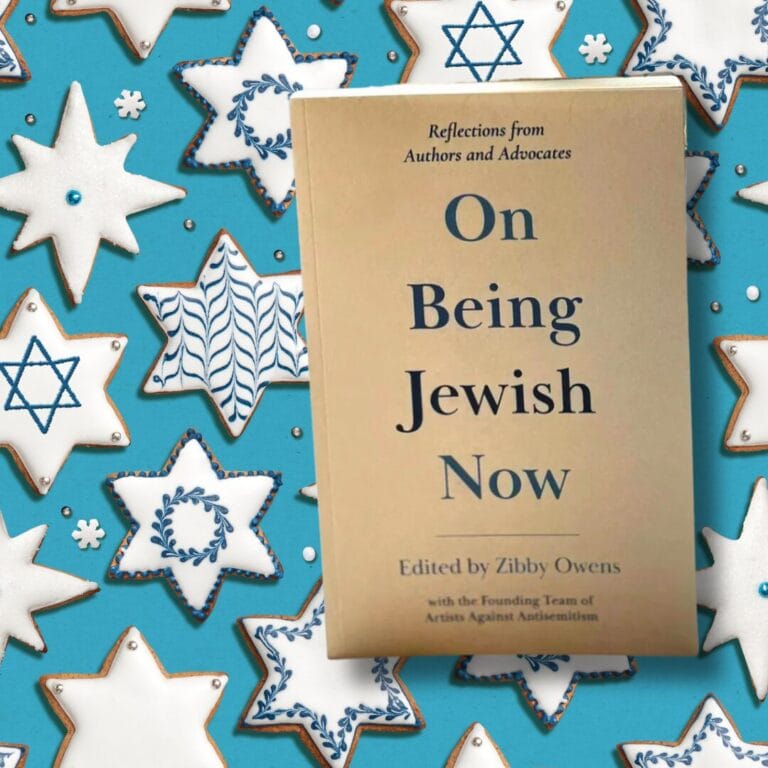 Book On Being Jewish Now on a background of star-shaped cookies with Star of David designs.
