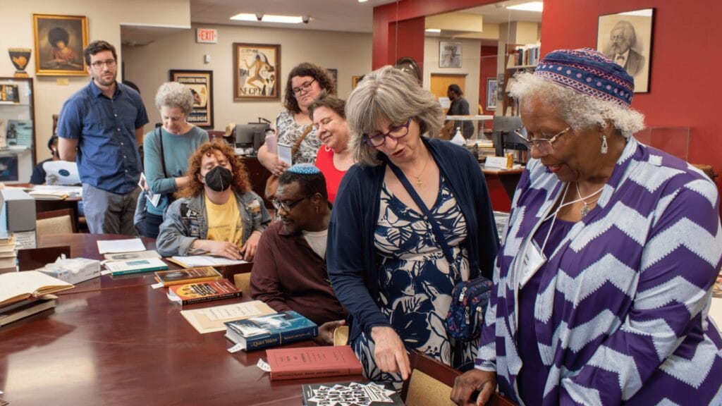 Participants in the 1299 Reckoning Project examine archival materials at Temple University.