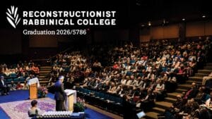A large audience watches a speaker at a graduation ceremony for the Reconstructionist Rabbinical College.