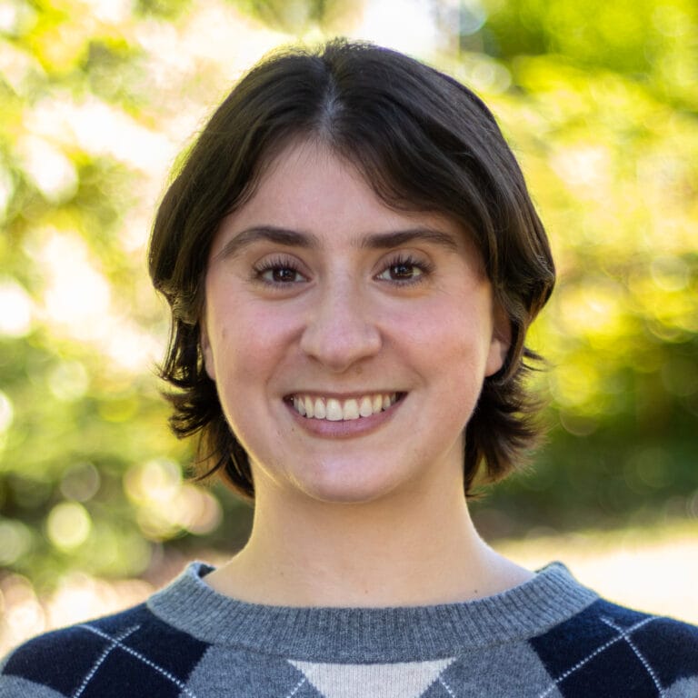 A young person with short brown hair smiling at the camera.